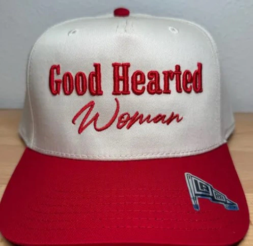 White and red trucker cap featuring red Good Hearted Woman embroidered lettering in bold and script styles.